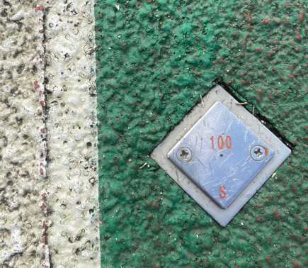 陸上競技場のトラックに引かれたラインの目印（100mのスタート地点のマーク）